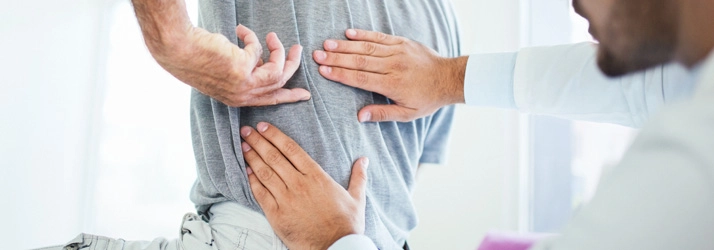 Chiropractic Naperville IL Back Exam Man Chiropractic practitioner assessing spinal alignment.