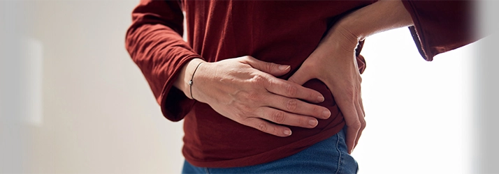 Chiropractic Naperville IL Side Pain Person holding their hip in pain.
